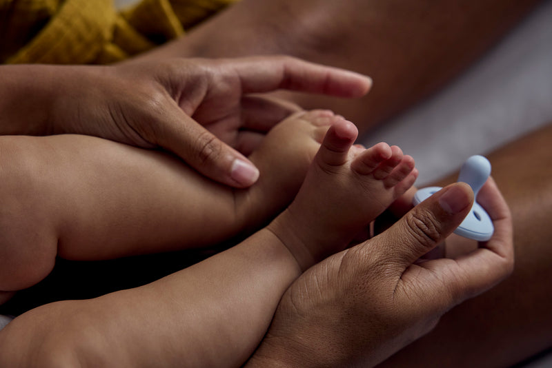 parent holding baby feet