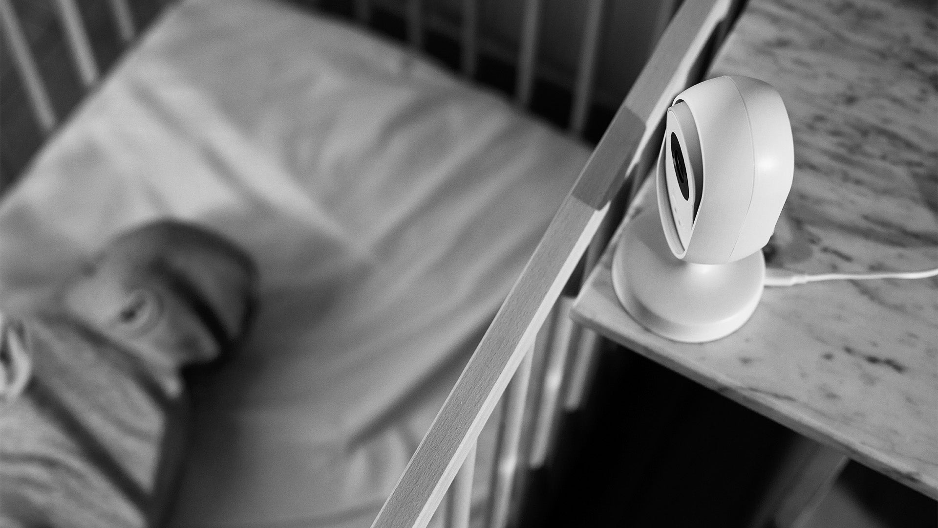 Baby asleep in cot with Dreamsense Monitor