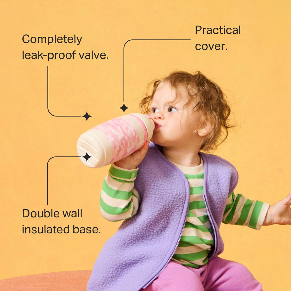 Toddler drinking from a pink camo insulated straw cup against an orange background with pointers to the product key features