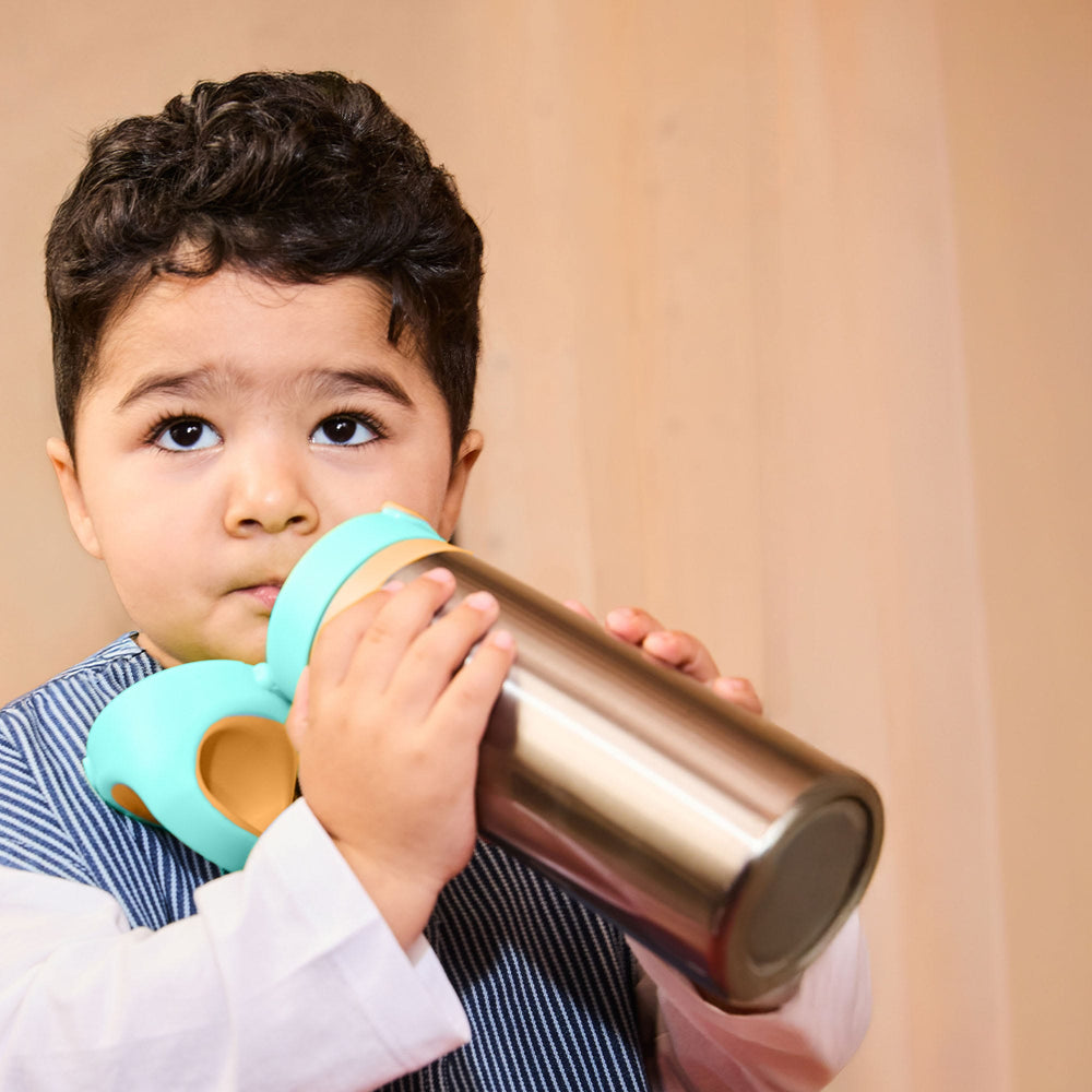 Toddler drinking from a Tommee Tippee On-the-Go Stainless Steel Insulated Bottle