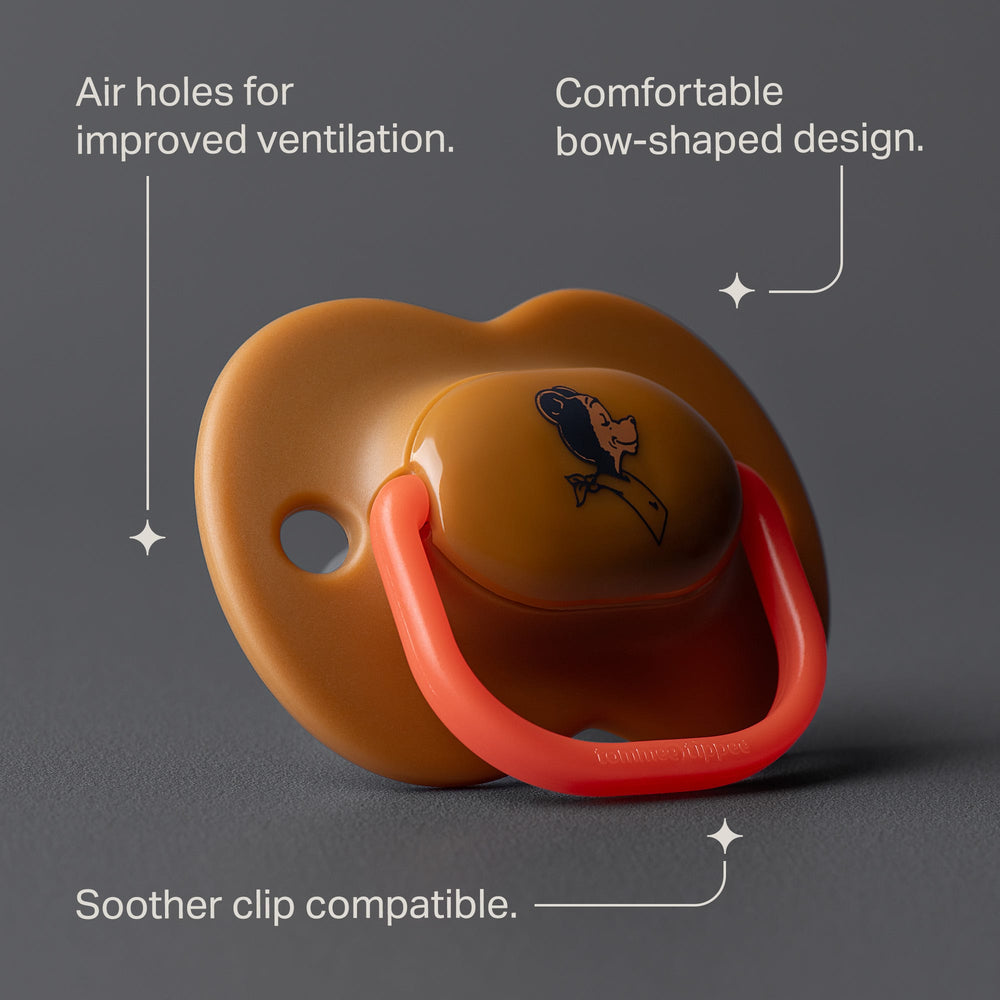 Tan soother against a grey background with pointers to the product key features