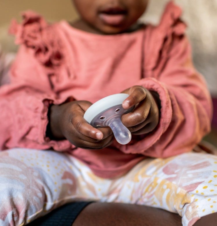 A Guide for Parents: How To Wash a Baby’s Clothes baby girl holding a soother