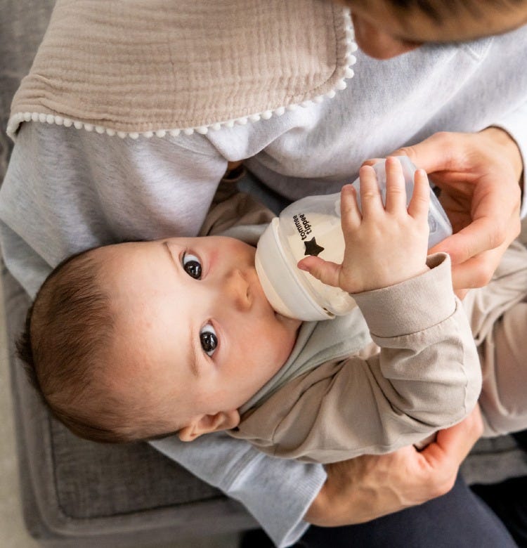 How to Make a Bottle of Formula Dad bottle feeding his baby using a Tommee Tippee bottle
