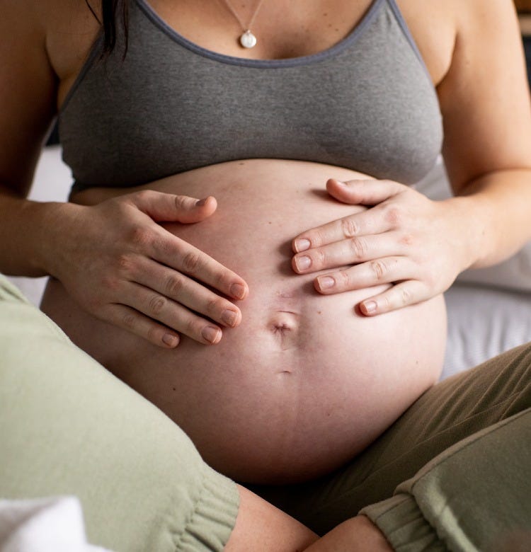 A Guide to Each Pregnancy Trimester Pregnant mum holding her bump