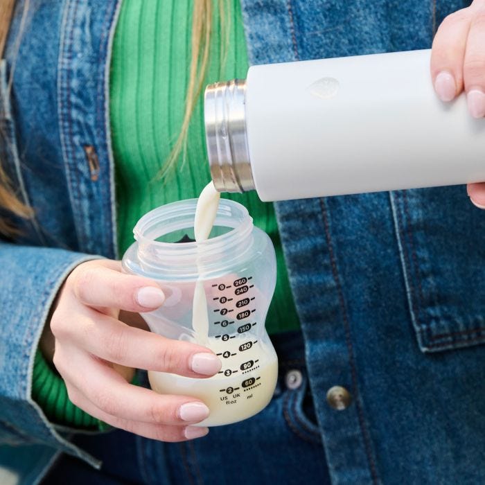 Person pouring milk from GoPrep into a baby bottle