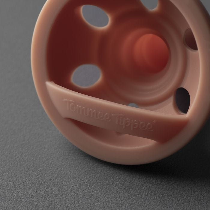 Close up of a breast-like soother&apos;s back on a dark grey background.