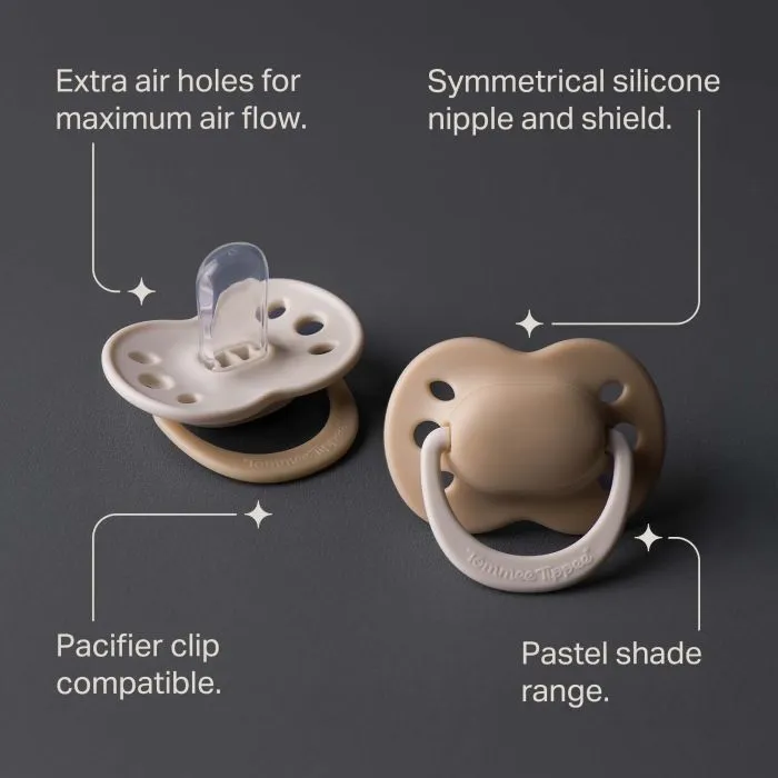 Two newborn pacifiers with key feature pointers on a charcoal background.