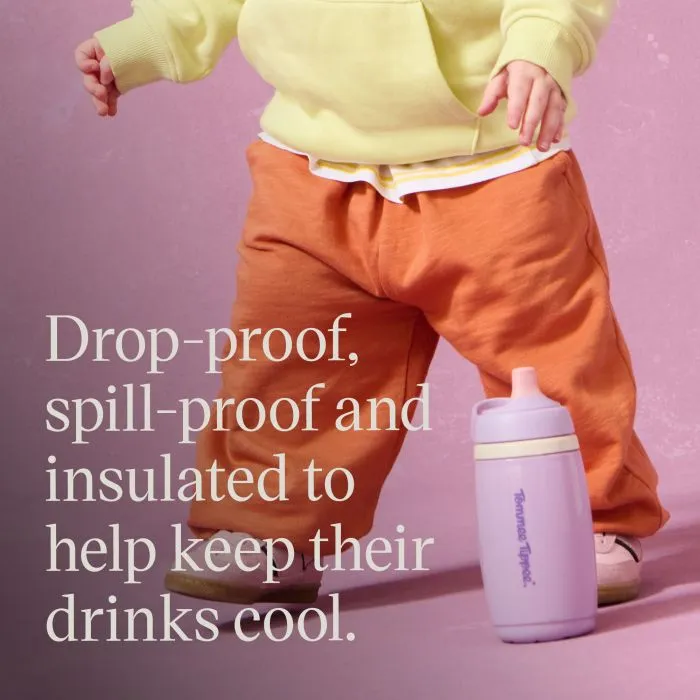 Image of a toddler standing against a pink background with an insulated active spout cup next to them on the floor and the product USP tagline alongside