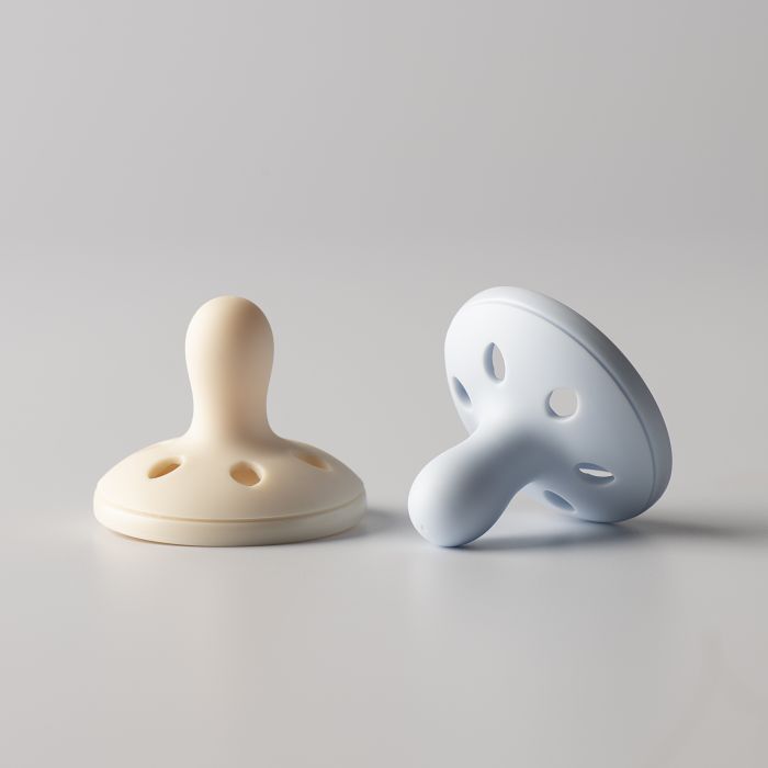 Breast-like soothers on a light grey background.