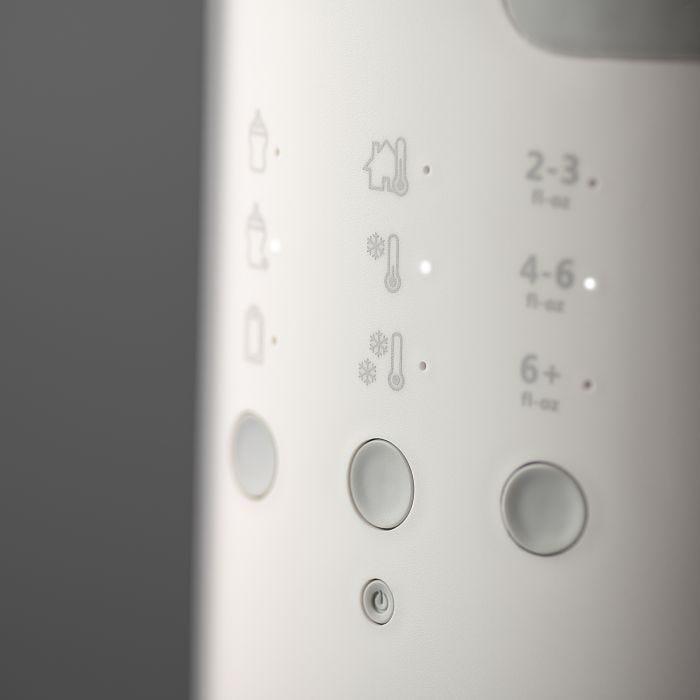 Close up image of the buttons on a Multiwarm bottle warmer against a grey background