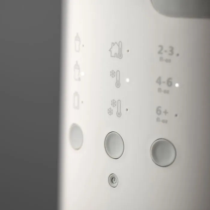 Close up image of the buttons on a Multiwarm bottle warmer against a grey background
