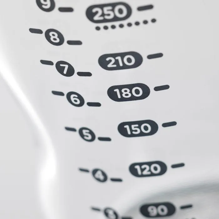 Close-up of the measurement markets on a glass baby bottle.