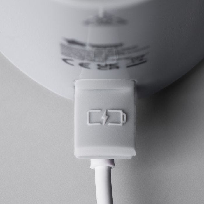 Gros plan du port de charge du chauffe-biberon portable LetsGo avec connexion USB sur un fond gris clair