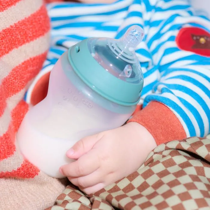 Close up image of a baby holding a silicone Natural Start bottle