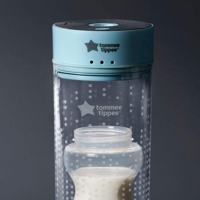 Baby bottle with milk inside the Colicsoothe on a grey background
