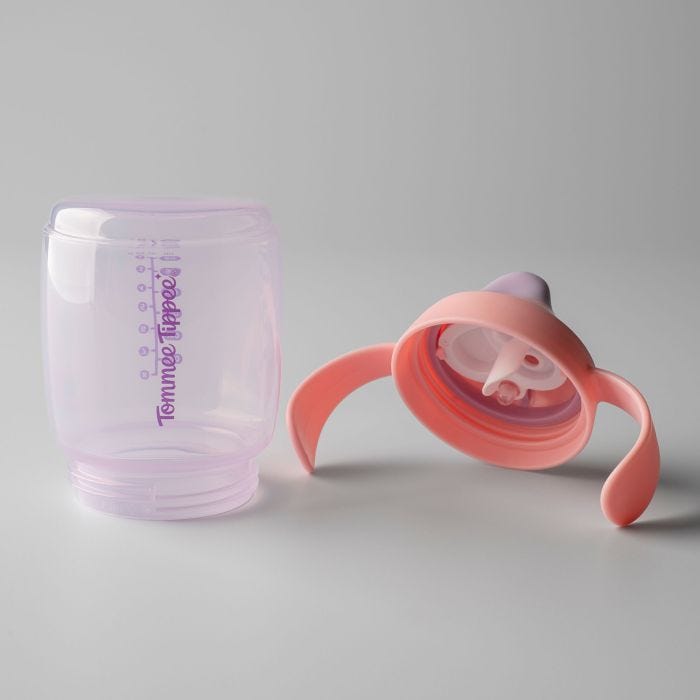 Pink Starter Spout cup base and lid laid out side by side against a grey background