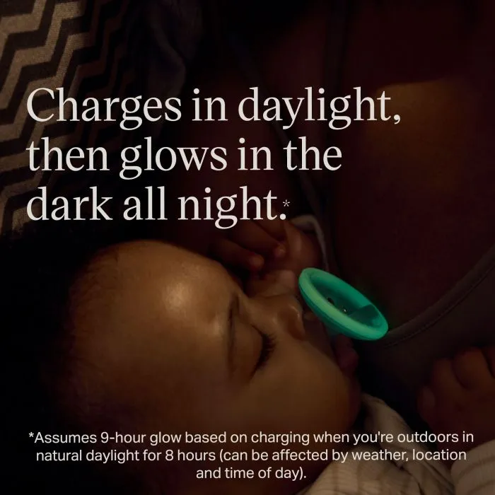 Baby with an illuminated glow in the dark pacifier with feature text.