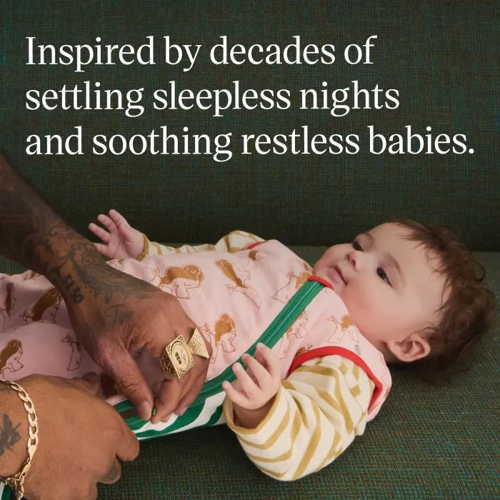 Baby wearing a Swaddle Bag with parent fastening the bottom to top zip.