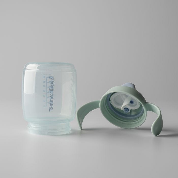 Base et couvercle de la tasse à bec de l&apos;entraîneur vert disposés côte à côte sur un fond gris