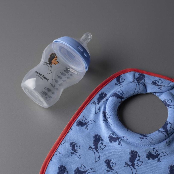 Milk bib and Natural Start bottle laid out against a dark grey background