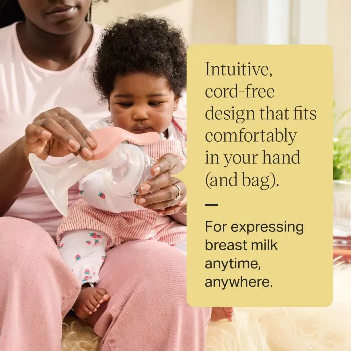 Parent assembling their cord-free breast pump while holding baby.