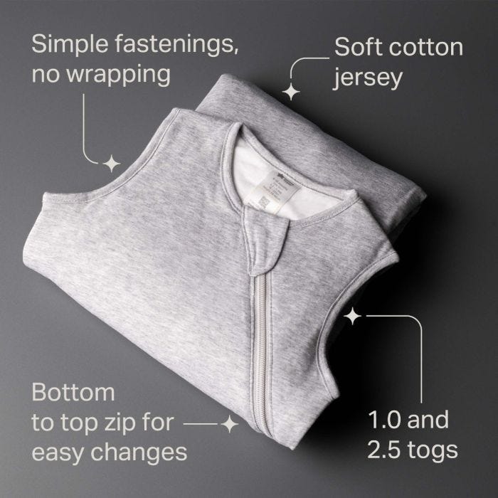 Folded grey baby sleep sack on a dark background. Features include simple fastenings, soft cotton jersey, bottom-to-top zip, and 1.0 and 2.5 togs.