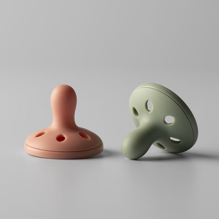 Breast-like soothers on a light grey background.