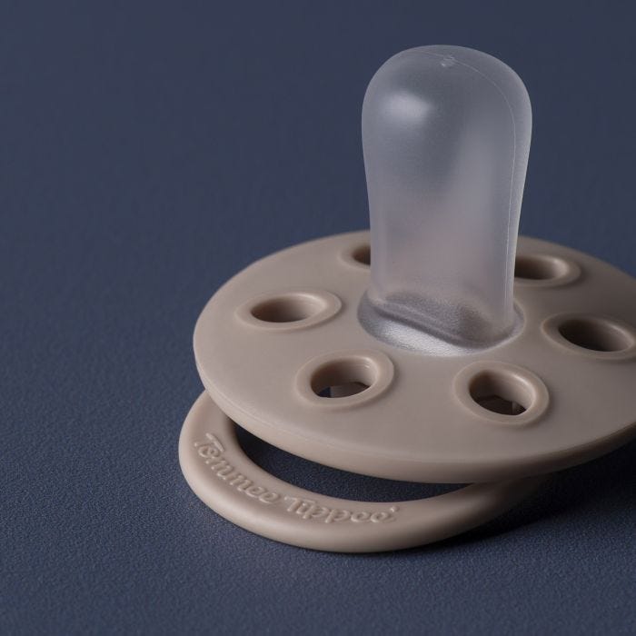 Close up of a Sculpted Clay soother silicone teat and shield with elliptical holes.