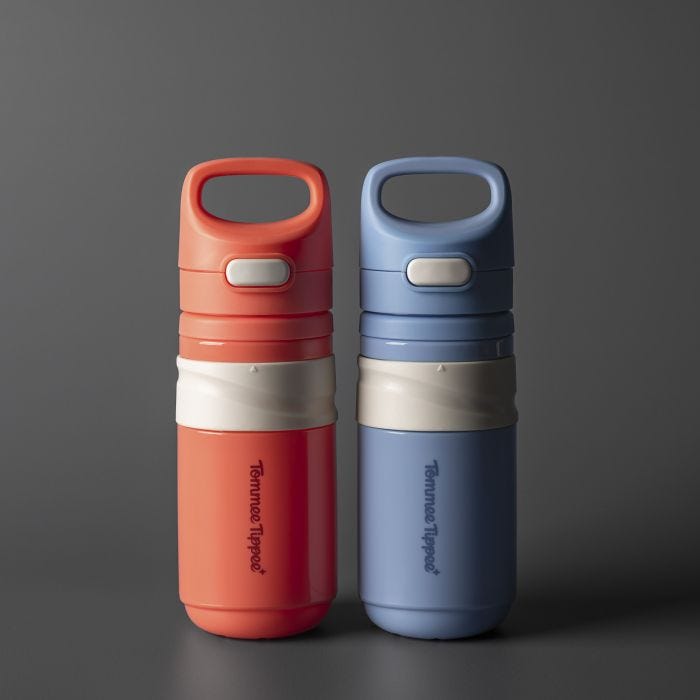 Red and blue on-the-go straw cups side by side against a dark grey background