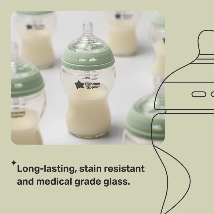 Glass baby bottles containing milk with text about resistant glass.
