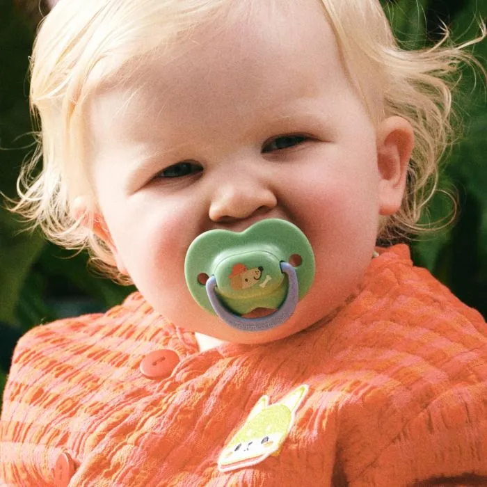 Baby with a 6+ months decorated Ultimate Fit soother.