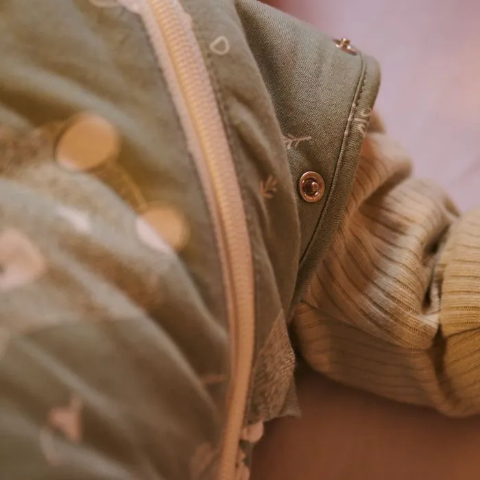 Close up of a woman’s hand zipping up a baby’s Swaddle Bag