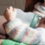Close up of baby drinking milk from a silicone bottle