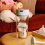 Baby bottle with milk inside the Colicsoothe on a coffee table