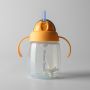 Orange trainer straw cup against a grey background