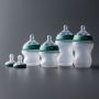 Wide shot of 5oz and 9oz silicone bottles and two breast-like pacifiers included in the set.