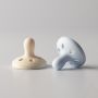 Breast-like soothers on a light grey background.