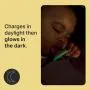 Baby with an illuminated pacifier with text about glowing in the dark.