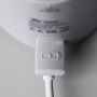 Gros plan du port de charge du chauffe-biberon portable LetsGo avec connexion USB sur un fond gris clair