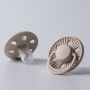 Two Sculpted Clay Style Edit soothers on a light grey background.