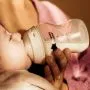 Woman feeding a baby using a Natural Start bottle