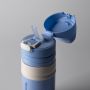 Close up of blue on-the-go cup open to show the straw against a light grey background