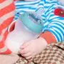 Close up image of a baby holding a silicone Natural Start bottle