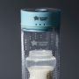 Baby bottle with milk inside the Colicsoothe on a grey background