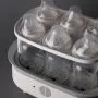 Steam steriliser open and filled with bottles against a grey background