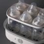 Steam steriliser open and filled with bottles against a grey background