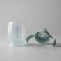 Base et couvercle de la tasse à bec de l&apos;entraîneur vert disposés côte à côte sur un fond gris