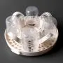 Microwave steriliser open and filled with bottles against a dark grey background