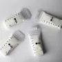 Five filled breast milk storage bags laying on a light grey background.