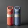 Red and blue on-the-go straw cups side by side against a dark grey background